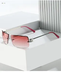 Detail of rimless oval sunglasses with red gradient lenses and silver metal hinges