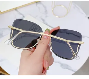 Detailed close-up of rimless gradient sunglasses with gold metal temples and modern design
