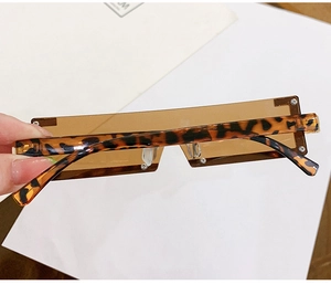 Détail de lunettes de soleil sans monture marron avec branches à motif léopard chic