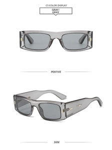 Detail view showing gray translucent square frame sunglasses with golden metal hinges