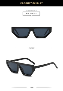 Detail view of black geometric diamond sunglasses with thick frames and dark grey lenses