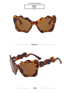 Detail of scalloped wavy frame sunglasses in demi tea color with matching curved arms