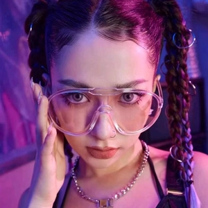 Front close-up of oversized transparent Y2K sunglasses on model with cyberpunk lighting