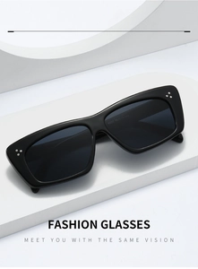 Detailed view of black cat-eye sunglasses with silver rivets on a white geometric background