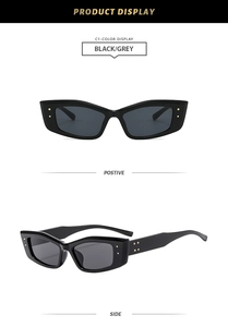 Close-up of black cat-eye sunglasses featuring golden square rivets and grey lenses