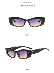 Close-up of retro black and leopard print sunglasses with gradient purple lenses and gold studs