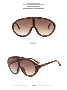 Detail view of large shield sunglasses with tortoiseshell frame and gradient brown lenses