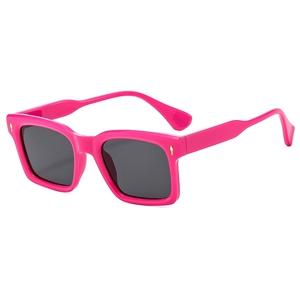 Retro square oversized sunglasses with pink frames and gold rivets on a white background