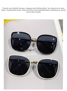 Detail of black and cream oversized sunglasses with gold metal hinges on a magazine