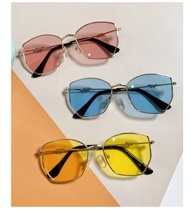 Close-up of geometric children's sunglasses with gold metal frames and colorful lenses