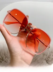 Vue détaillée de lunettes de soleil carrées en métal doré avec verres dégradés orange