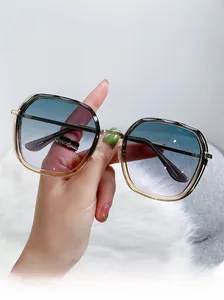 Detail shot of large frame sunglasses with blue-purple gradient lenses and gold metal frames