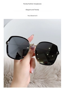 Détail de lunettes de soleil carrées avec monture en métal doré et verres dégradés gris