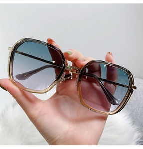 Detail of square gold metal sunglasses featuring gradient blue and pink lenses