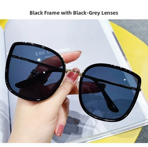 Close-up of black oversized square sunglasses with metal nose bridge and dark grey lenses