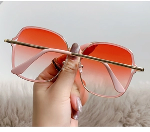 Détail de lunettes de soleil carrées vintage avec verres dégradés orange et monture dorée