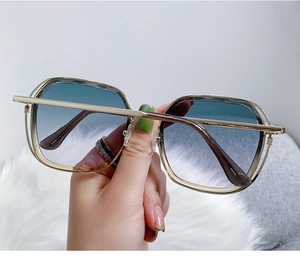 Macro shot of gold metal frame sunglasses with gradient blue to purple lenses