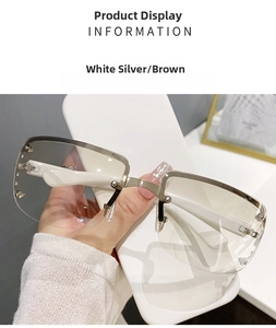 Detail of white silver half-frame sunglasses with brown lenses and metal rivets