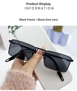 Detail view of black square sunglasses with dark grey lenses and metal nose bridge