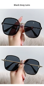 Détail de lunettes de soleil vintage en métal avec verres gris noir et monture dorée