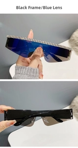 Détail de lunettes de soleil oversize sans monture, verres bleus et bordure en cristaux