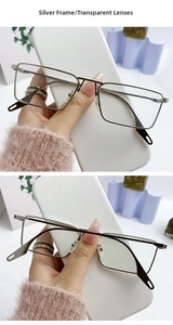 Detail of silver metal frame glasses with rectangular shape and transparent lenses
