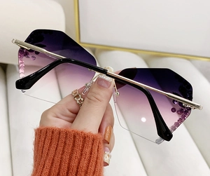 Détail de lunettes papillon sans monture avec verres dégradés violets et strass brillants
