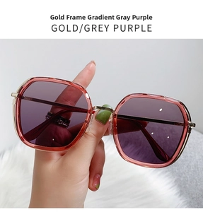 Detail of oversized gold metal frames with gradient grey-purple lenses on fur background