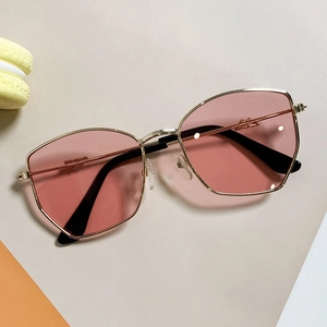 Pink octagonal children sun glasses with thin gold frame on a minimal background