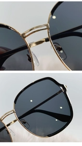 Vue détaillée de lunettes de soleil dorées avec plaquettes de nez et monture en métal poli