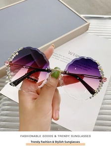 Detail of rimless sunglasses with rhinestone-encrusted wavy edges and gradient lenses