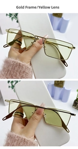 Close-up of gold metal frame sunglasses with vintage yellow tinted rectangle lenses