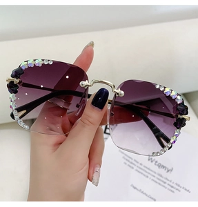 Detail einer randlosen lila Farbverlauf-Sonnenbrille mit Kristallblumenverzierung