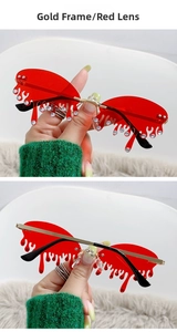 Détail de lunettes de soleil rouges sans monture en forme de larme avec strass dorés