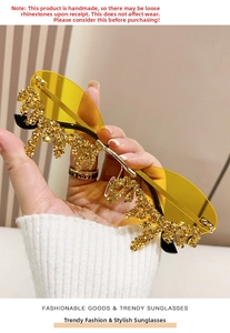 Macro shot of rimless sunglasses with yellow lenses and hanging gold teardrop crystals