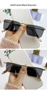 Detail of gold metal frame rectangular sunglasses with black grey lenses and double bridge