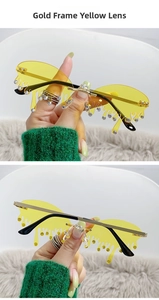 Détail de lunettes de soleil jaunes effet fondu avec strass et monture dorée