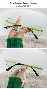 Détail de lunettes de soleil sans monture vertes en forme de larme avec strass et branches dorées