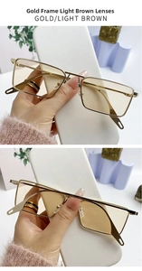 Detail of minimalist gold rectangle sunglasses with light tea lenses and slim metal frame
