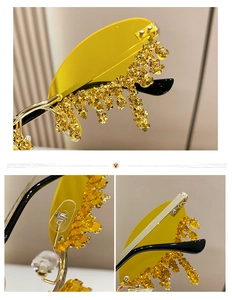 Detail of rimless angel tear sunglasses featuring yellow lenses and gold crystal tassels