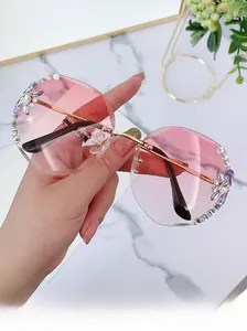 Close-up of rimless sunglasses with pink gradient lenses and hand-set crystal rhinestones