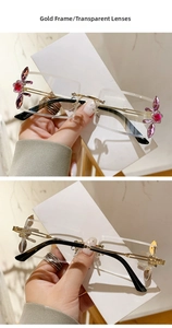 Detail of rimless gold frames with pink butterfly crystals on transparent lenses