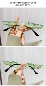 Details einer goldenen Flammen-Sonnenbrille mit grünen Strasssteinen und Gläsern