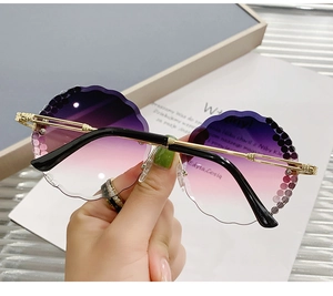 Close-up of rimless gradient lenses with wavy petal-cut edges and sparkling rhinestones