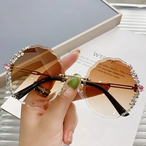 Fashionable rimless round sunglasses with wavy edges and handcrafted floral rhinestones
