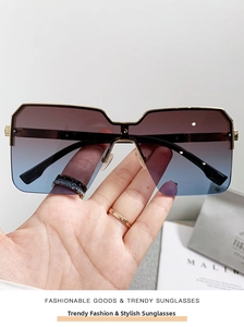 Dettaglio di occhiali da sole oversize in metallo con lenti sfumate e stile lusso