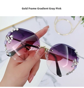 Close-up of rimless gradient grey pink sunglasses with sparkling rhinestone flower detail