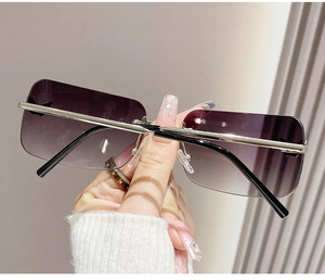 Detail of rimless rectangle sunglasses with purple gradient lenses and metal temples