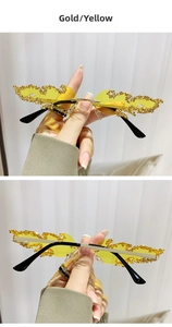 Detail der goldfarbenen Flammen-Sonnenbrille mit gelben Gläsern und funkelnden Kristallen