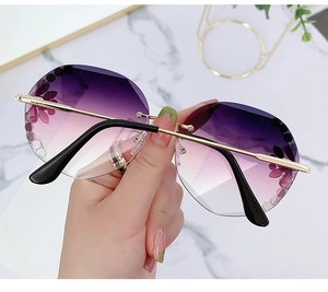 Detail of rimless sunglasses with purple gradient lenses and floral rhinestone accents